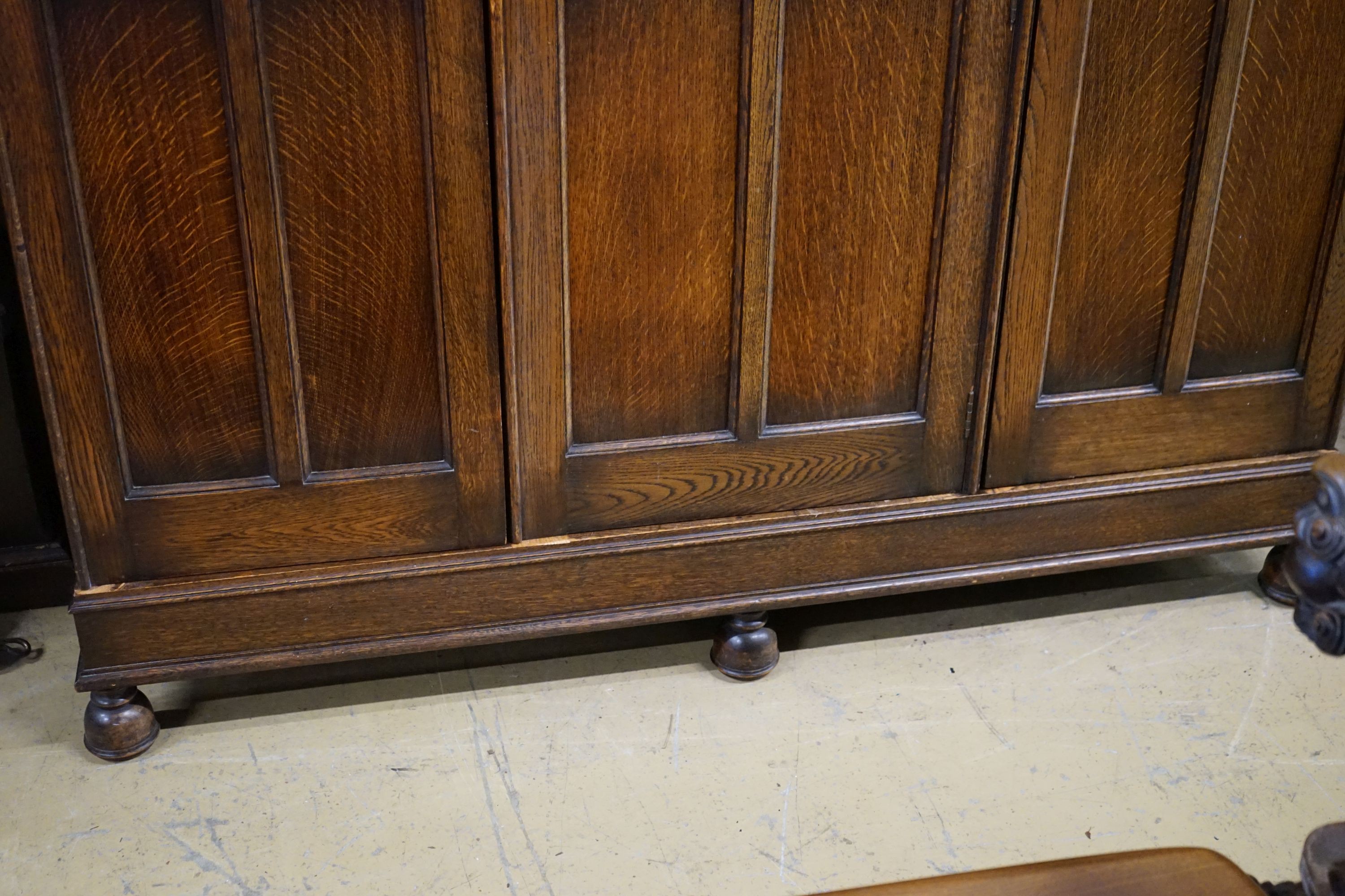 A carved and panelled oak triple wardrobe with fitted interior, length 150cm, depth 49cm, height 200cm